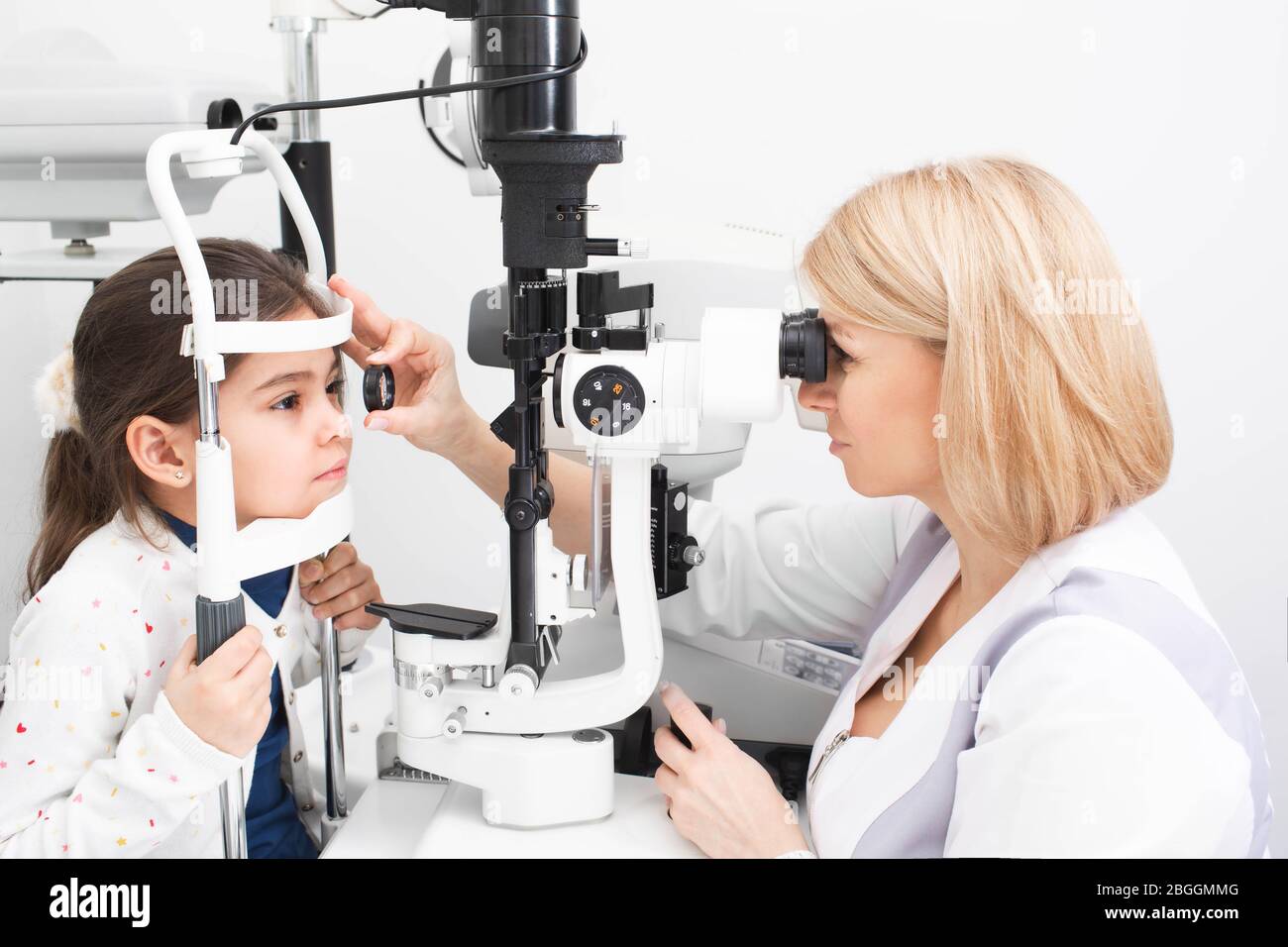 Optométriste examine la rétine de l'œil d'une fille avec un équipement ophtalmique spécial dans une clinique moderne. Correction de la vision chez les enfants Banque D'Images