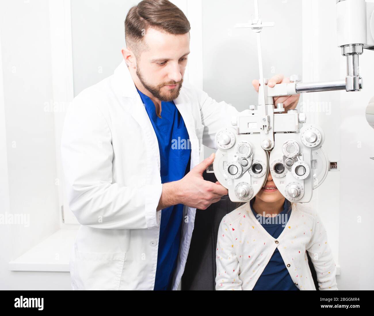 Optométriste médecin vérifie la vue de la jeune fille. Si la fille a une mauvaise vue, le médecin donnera une ordonnance pour les verres Banque D'Images