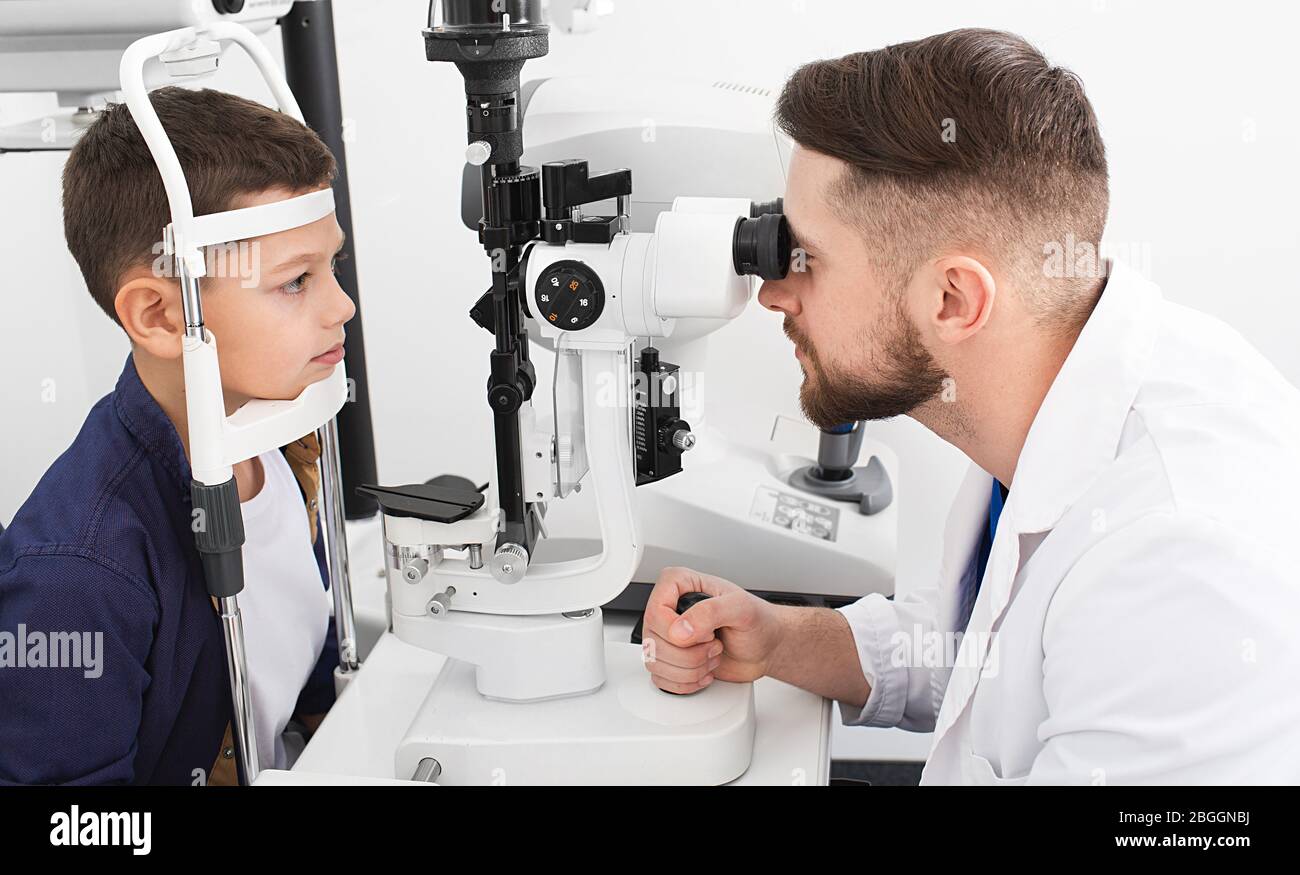 L'ophtalmologiste mâle vérifie la vue d'un adolescent avec un équipement ophtalmique spécial. Garçon a très bonne vue Banque D'Images