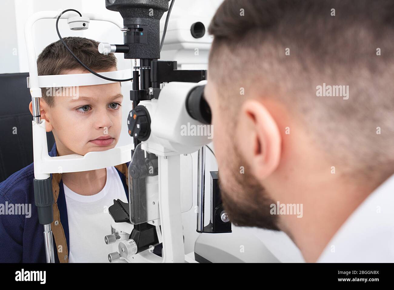 Optométriste examine le garçon d'un patient avec un équipement ophtalmique spécial dans une clinique moderne. Correction de la vision chez les enfants Banque D'Images