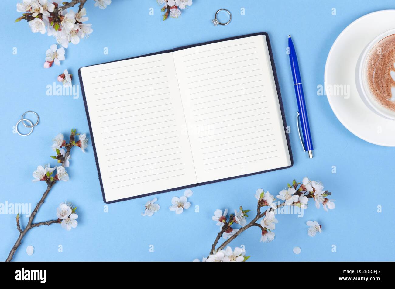 Liste de souhaits pour les plans futurs. composition de plat avec fleurs et bloc-notes et café avec art du café Banque D'Images
