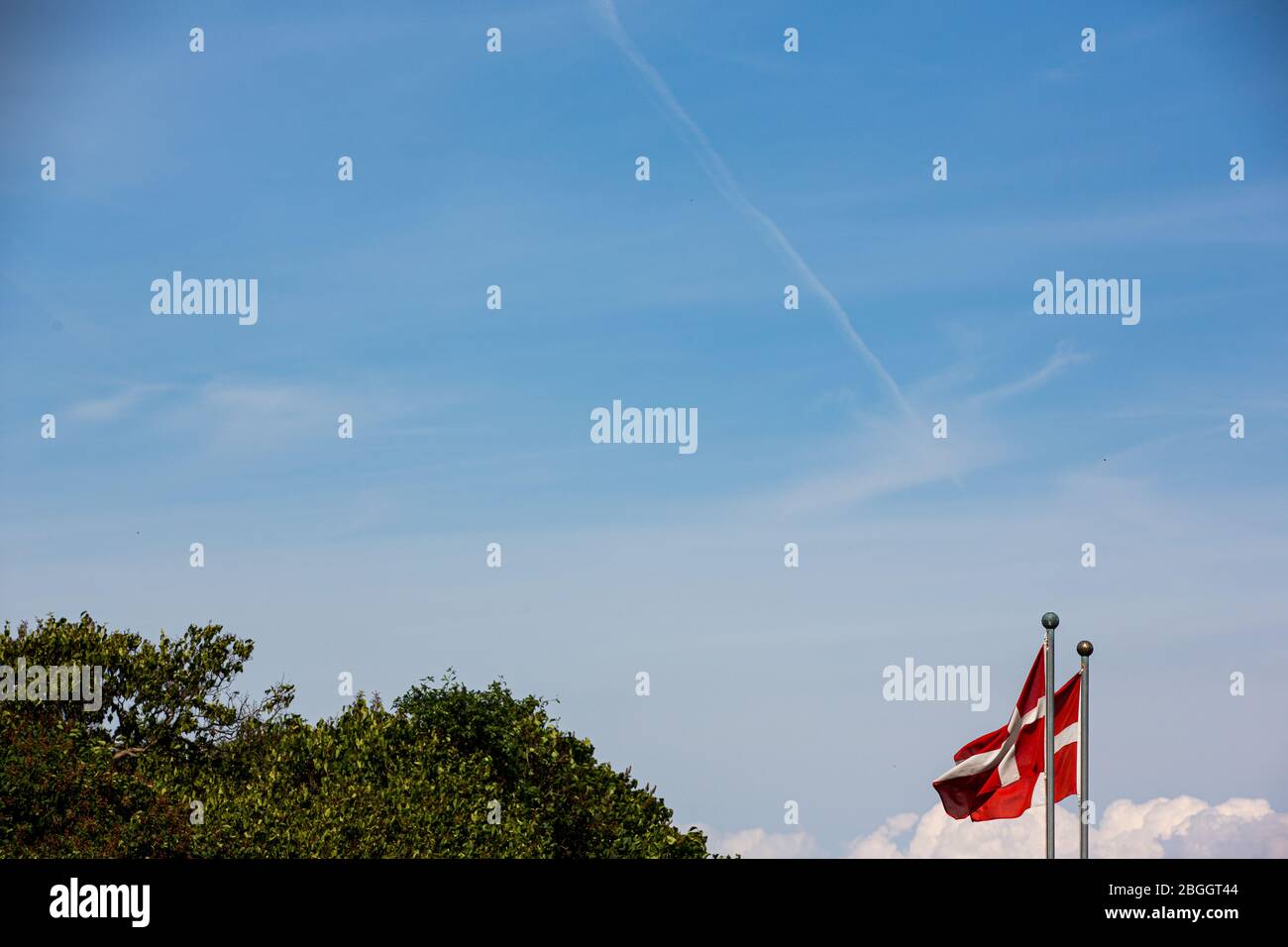 Drapeaux danois au vent sur une journée d'été claire, sur le ciel bleu Banque D'Images