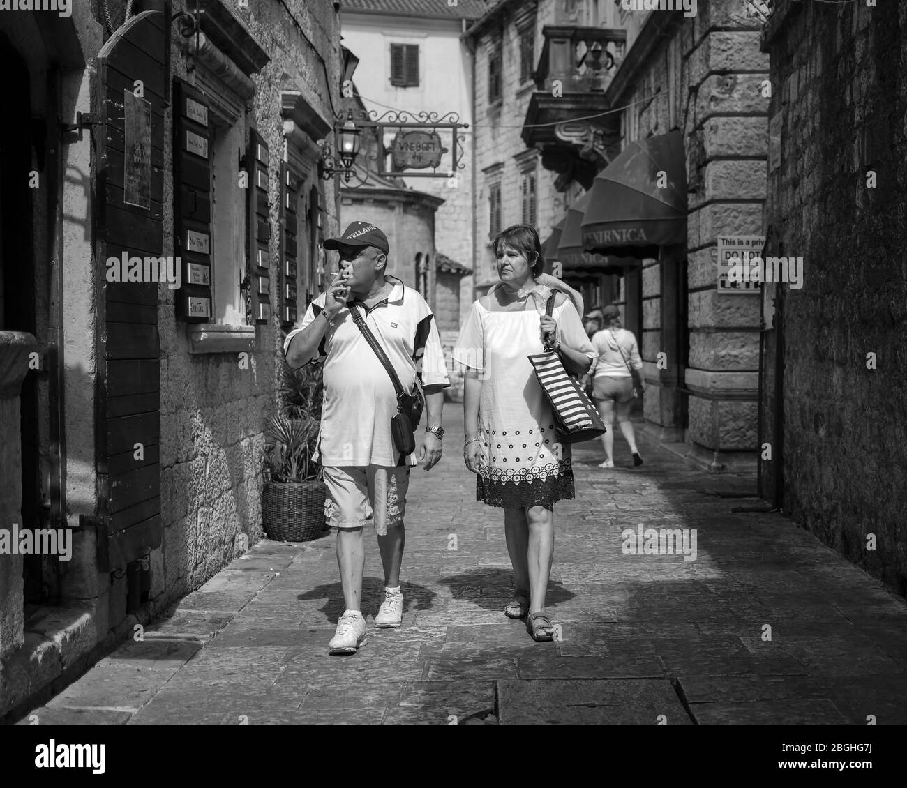 Monténégro, 17 septembre 2019 : couple descendant la rue pavée étroite de la vieille ville de Kotor (N/B) Banque D'Images