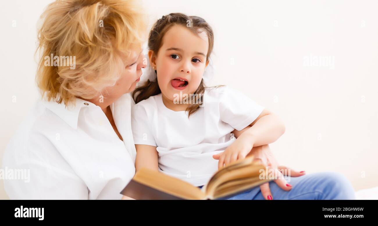 Grand-mère lisant un conte à sa petite-fille de bébé. Loisirs de lecture en famille. Temps de qualité. Bonne famille s'amuser à jouer à la maison. Banque D'Images