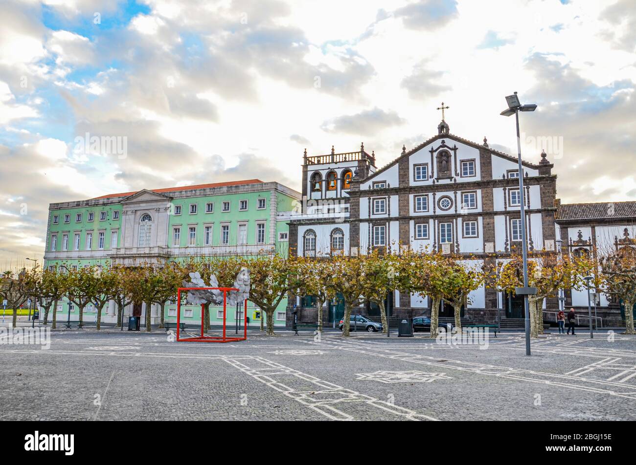 Ponta Delgada, Açores, Portugal - 12 janvier 2020: Place pavée dans le centre historique de la ville portugaise. Maisons historiques traditionnelles. Coucher de soleil ciel avec nuages. Photo horizontale. Banque D'Images