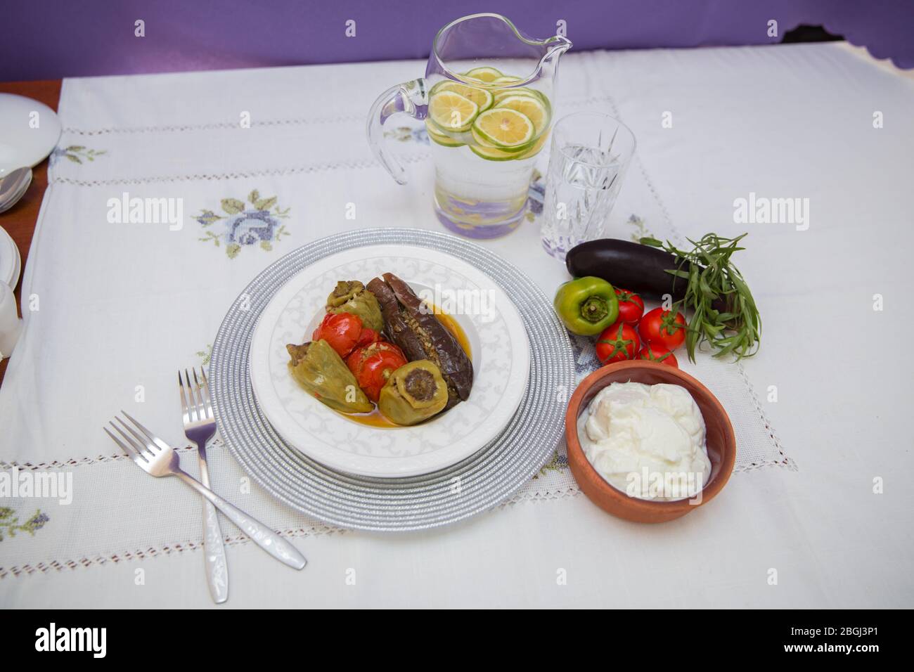 Les aubergines sont farcies d'agneau à la viande et de riz. Plican . remplissage de l'aubergine . Aubergine, poivrons, tomates . Yaourt dans un bol marron . Citron haché dans un Banque D'Images