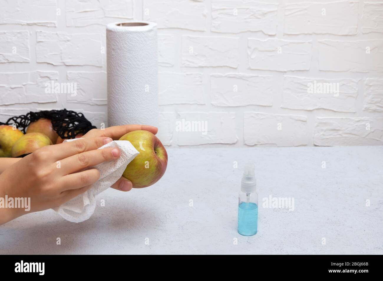 Laver les fruits et les produits pendant le Coronavirus. Femme mains nettoyer les pommes avec de l'aseptisant Banque D'Images
