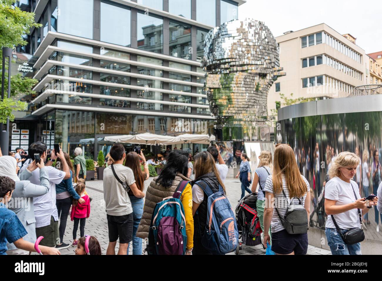 Les gens, touristes regardant le chef de Franz Kafka connu sous le nom de Statue de Kafka sculpture extérieure par David Cerny, installé à l'extérieur des magasins Quadrio Banque D'Images