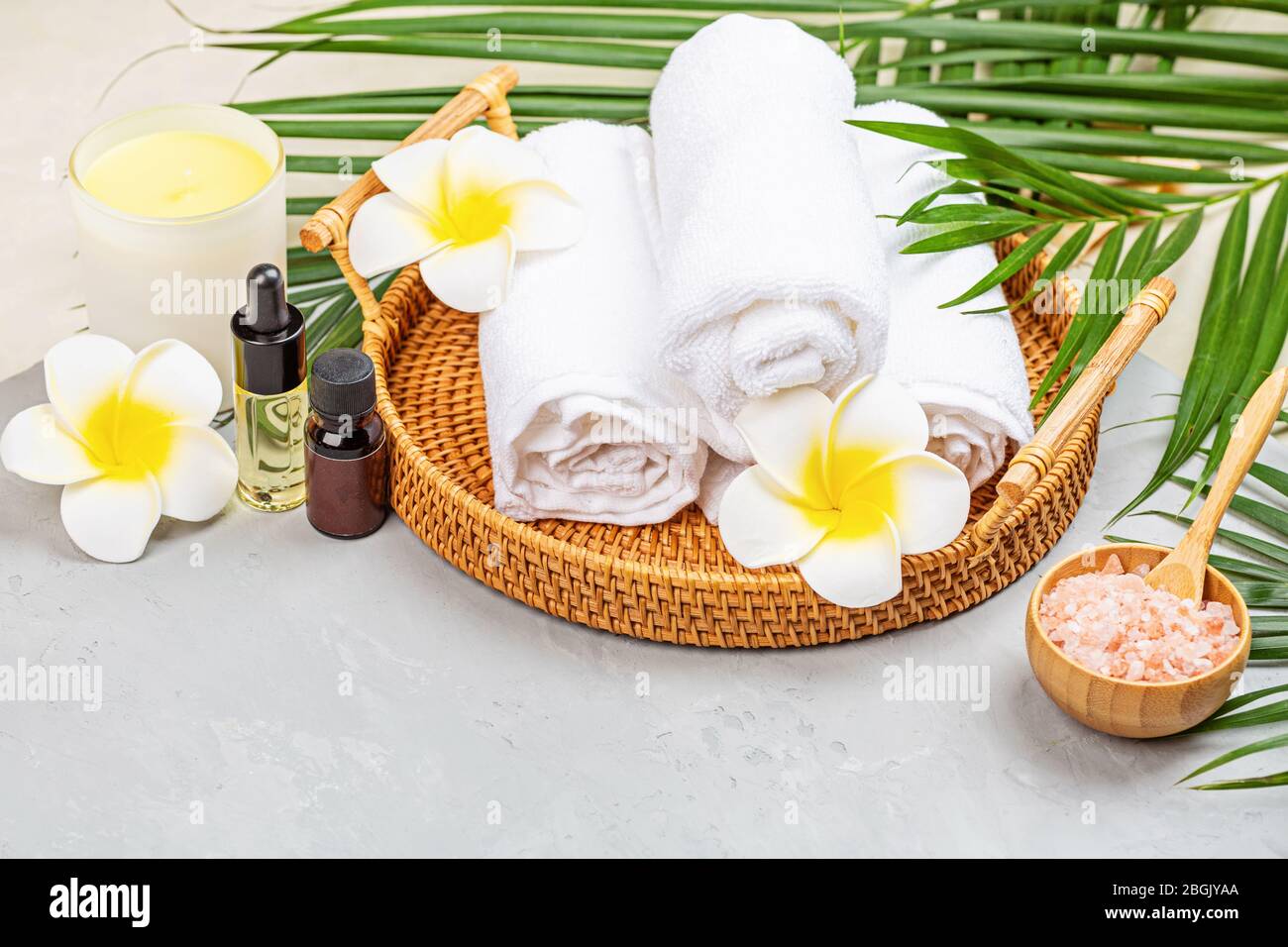 Massage spa soins du corps aromathérapie. Boules de plantes de spa,  cosmétiques, serviettes et feuilles tropicales sur table en béton gris. Vue sur  le dessus, plat Photo Stock - Alamy