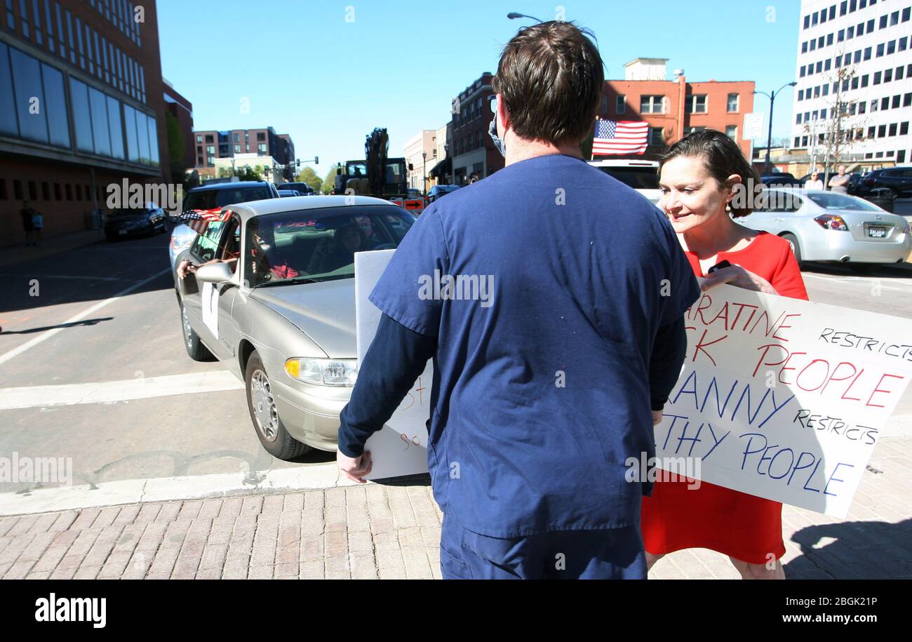 Clayton, États-Unis. 21 avril 2020. Les personnes ayant des panneaux se trouvent dans la rue, bloquant ceux qui sonnent leurs cornes et conduisant par le Centre du gouvernement du comté de St. Louis, lors d'une manifestation en voiture à Clayton, Missouri, le mardi 21 avril 2020. Les gens qui conduisent autour du bloc et ceux qui ont des signes, applaudissaient sur les trottoirs protestent contre le fait que les entreprises du Missouri sont fermées en raison de la pandémie de coronavirus. Photo de Bill Greenblatt/UPI crédit: UPI/Alay Live News Banque D'Images