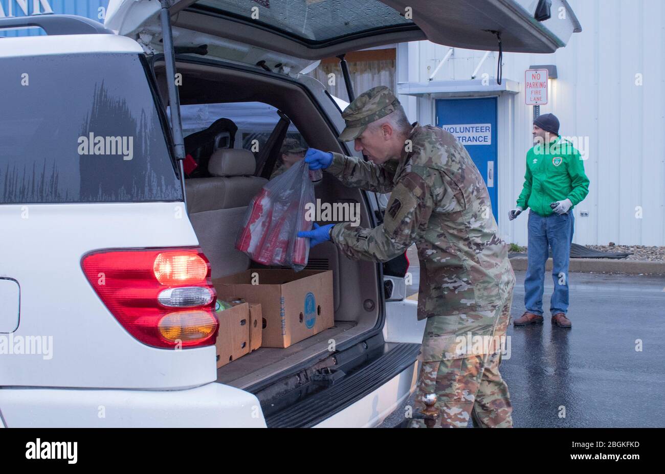 CPT. Eric Bolin, officier d'entraînement du 1 Bataillon 293 Infantry Regiment, charge les provisions à l'arrière d'un véhicule à la Community Harvest Food Bank à fort Wayne, Ind. Le 28 mars 2020. La Community Harvest Food Bank et la Garde nationale de l'Indiana ont travaillé ensemble pour aider à répondre aux besoins de Hoosiers qui luttent pour nourrir leurs familles pendant la crise de la COVID-19. Banque D'Images