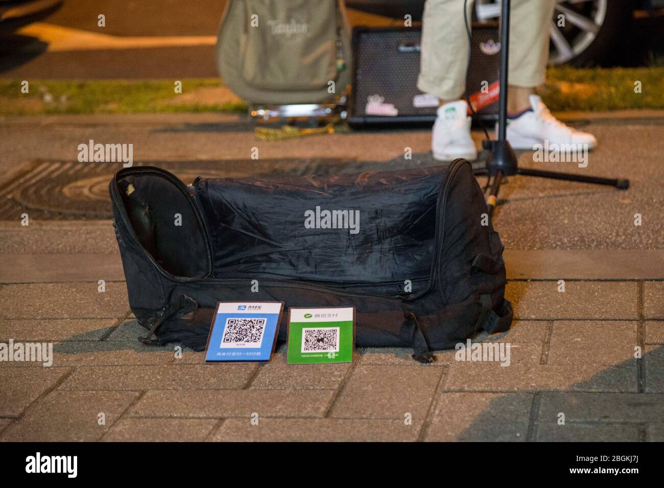 --FILE--deux jeunes hommes chantent dans la rue avec le code QR, via lequel les passants peuvent transférer de l'argent pour les soutenir, ville de Guangzhou, Guangdon de Chine méridionale Banque D'Images