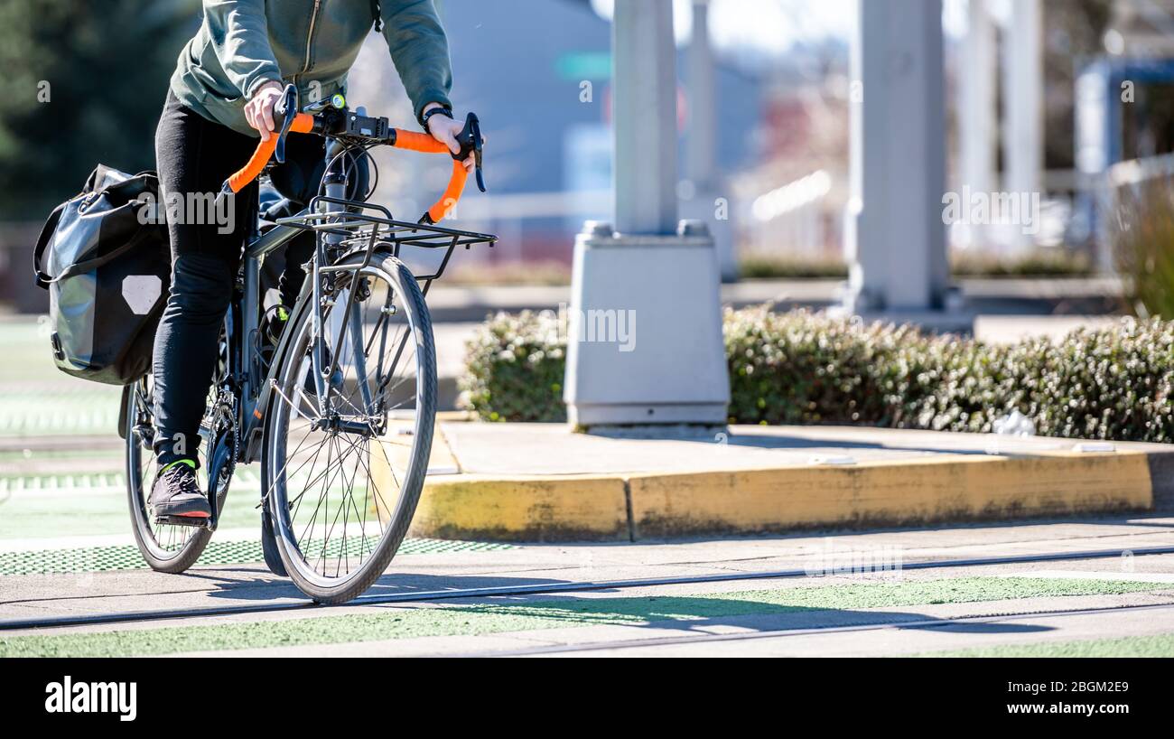 Un homme sur une pédale de vélo un vélo traverse des pistes de tram sur un passage dédié pour les cyclistes et les piétons préférant un mode de vie sain à vélo r Banque D'Images