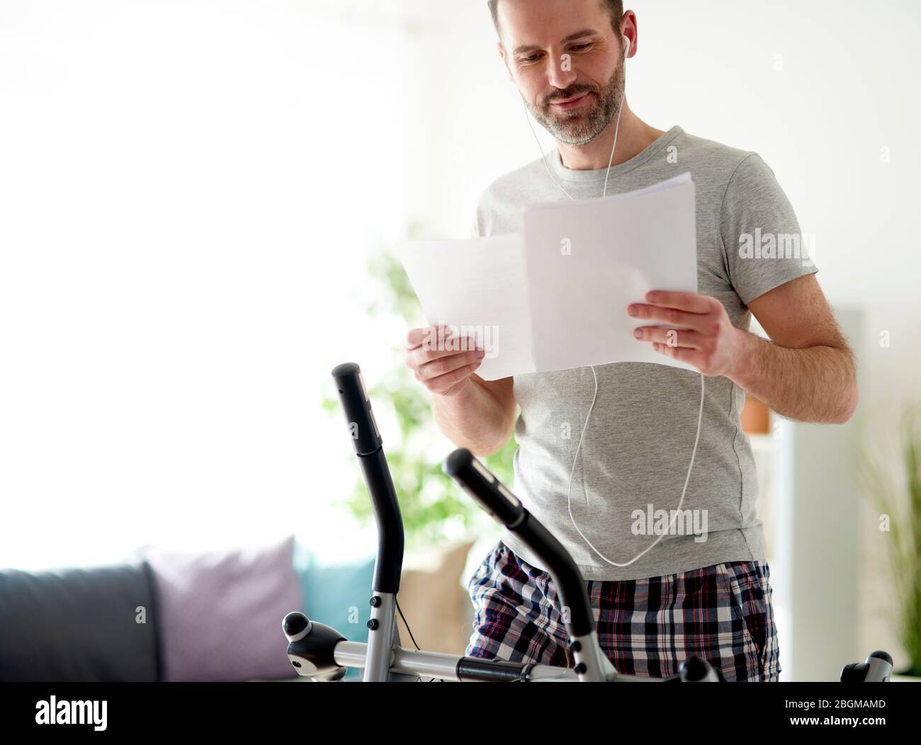 Homme exerçant sur le cross-formateur pendant une quarantaine Banque D'Images