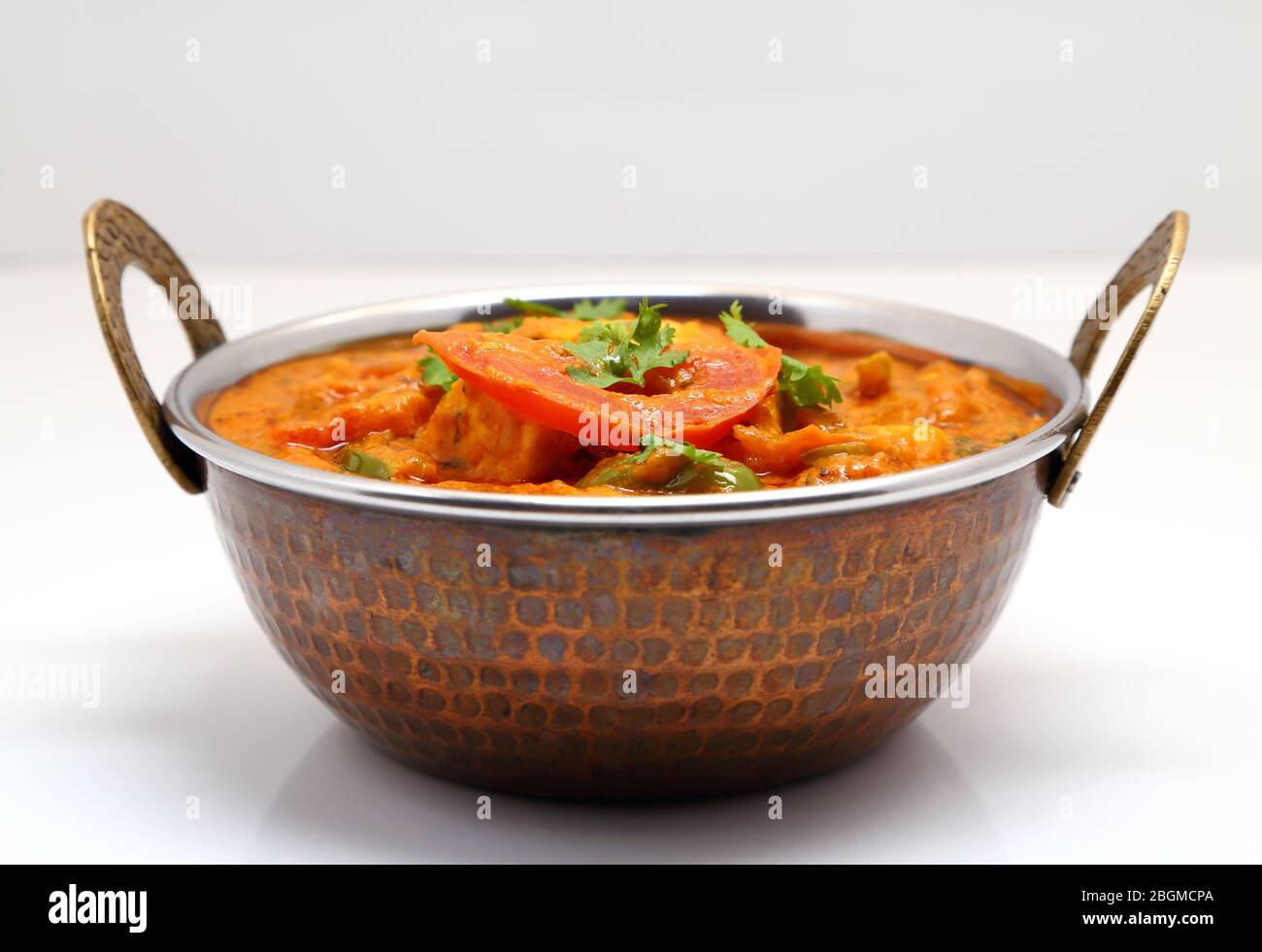 La nourriture indienne ou indien Curry dans un cuivre laiton bol de service. Banque D'Images