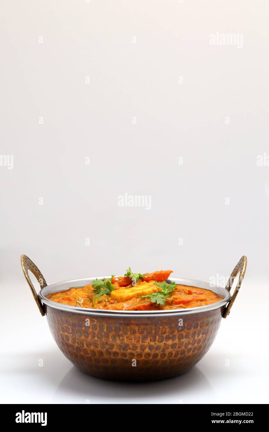 La nourriture indienne ou indien Curry dans un cuivre laiton bol de service. Banque D'Images