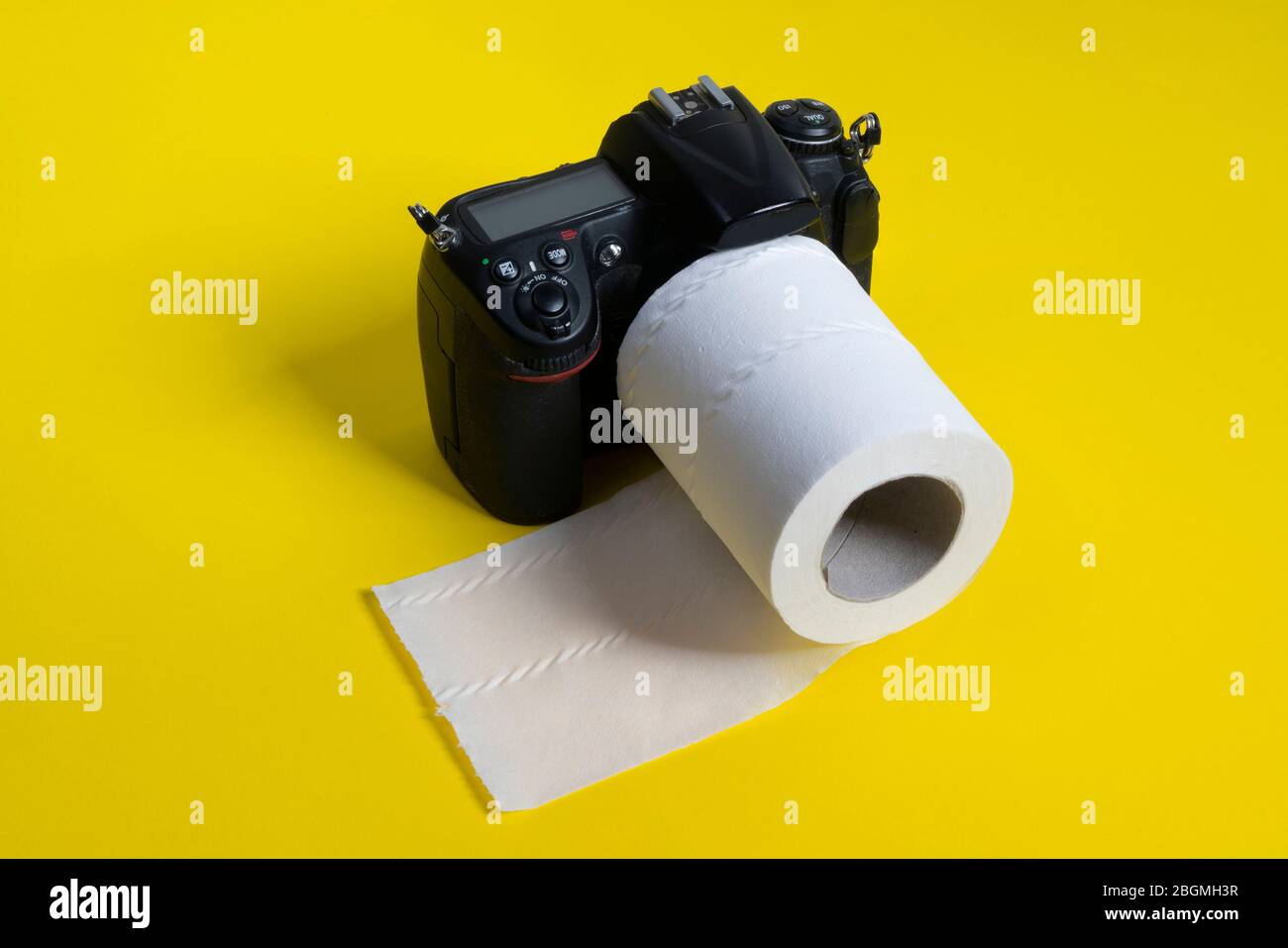 Un appareil photo reflex avec un rouleau de papier toilette comme