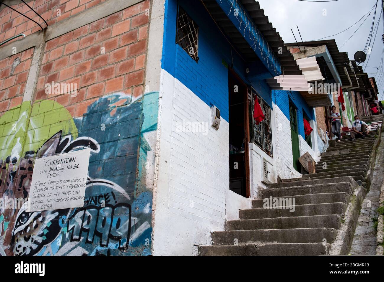 Ciudad Bolivar, Colombie. 22 avril 2020. "Avec la faim, vous ne pouvez pas maintenir la quarantaine" est écrit sur un panneau à côté de plusieurs maisons dans le quartier de Ciudad Bolivar au sud de Bogota, avec des chiffons rouges pendants d'eux. Les foulards rouges sont devenus un symbole pour les personnes dans le besoin en Colombie : les citoyens qui ont perdu leur emploi ou qui ont un faible revenu en raison de la crise de Corona accrochent des foulards rouges sur leurs fenêtres pour indiquer qu'ils ont besoin d'aide. Crédit: Luiis Carlos Ayala//Luis Carlos Ayala/dpa/Alay Live News Banque D'Images