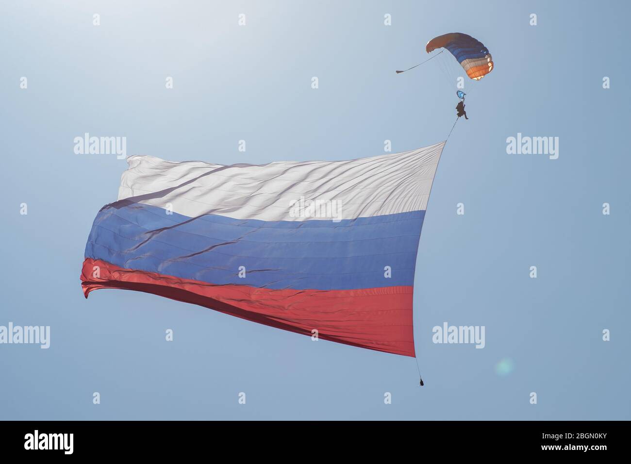 Skydiver dans le ciel avec un drapeau géant de la Russie contre le ciel bleu. Banque D'Images
