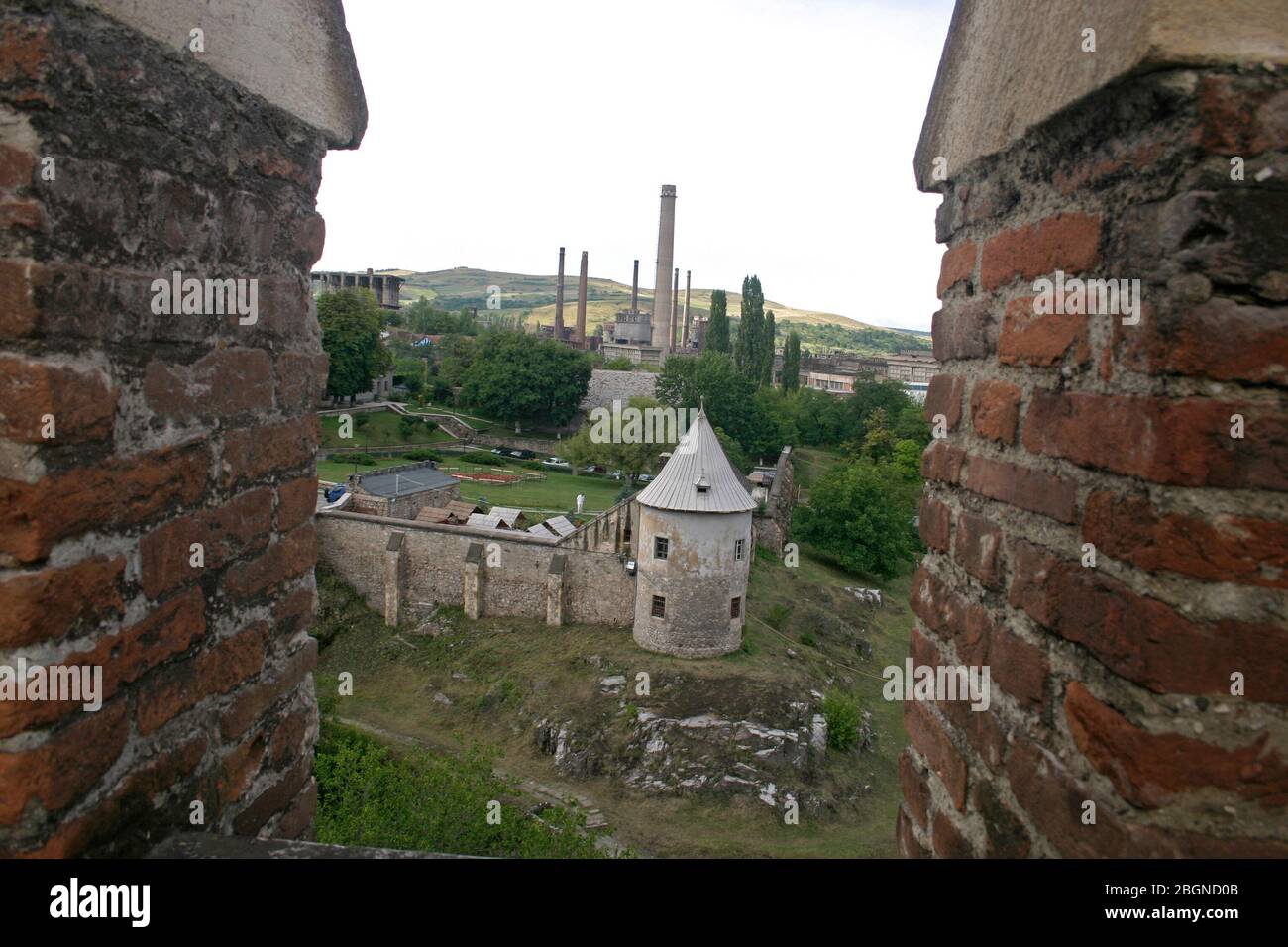 Hunedoara, Roumanie. Vue du château historique de Corvin vers l'aciérie adjacente, avec ses bâtiments industriels. Banque D'Images