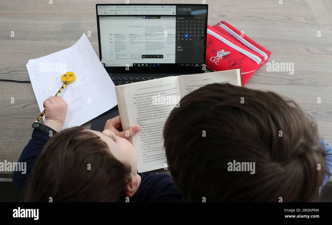 PA a demandé à ses photographes de prendre une photo à MIDI pour montrer l'impact du coronavirus sur le Royaume-Uni et l'Irlande. Un élève de première classe à Dublin lit à son frère plus jeune, comme selon son calendrier de scolarité à la maison, midi est CHER (tout laisser tomber et lire) temps que les magasins et les entreprises restent fermés et la population en verrouillage dans la lutte continue contre le coronavirus. Banque D'Images