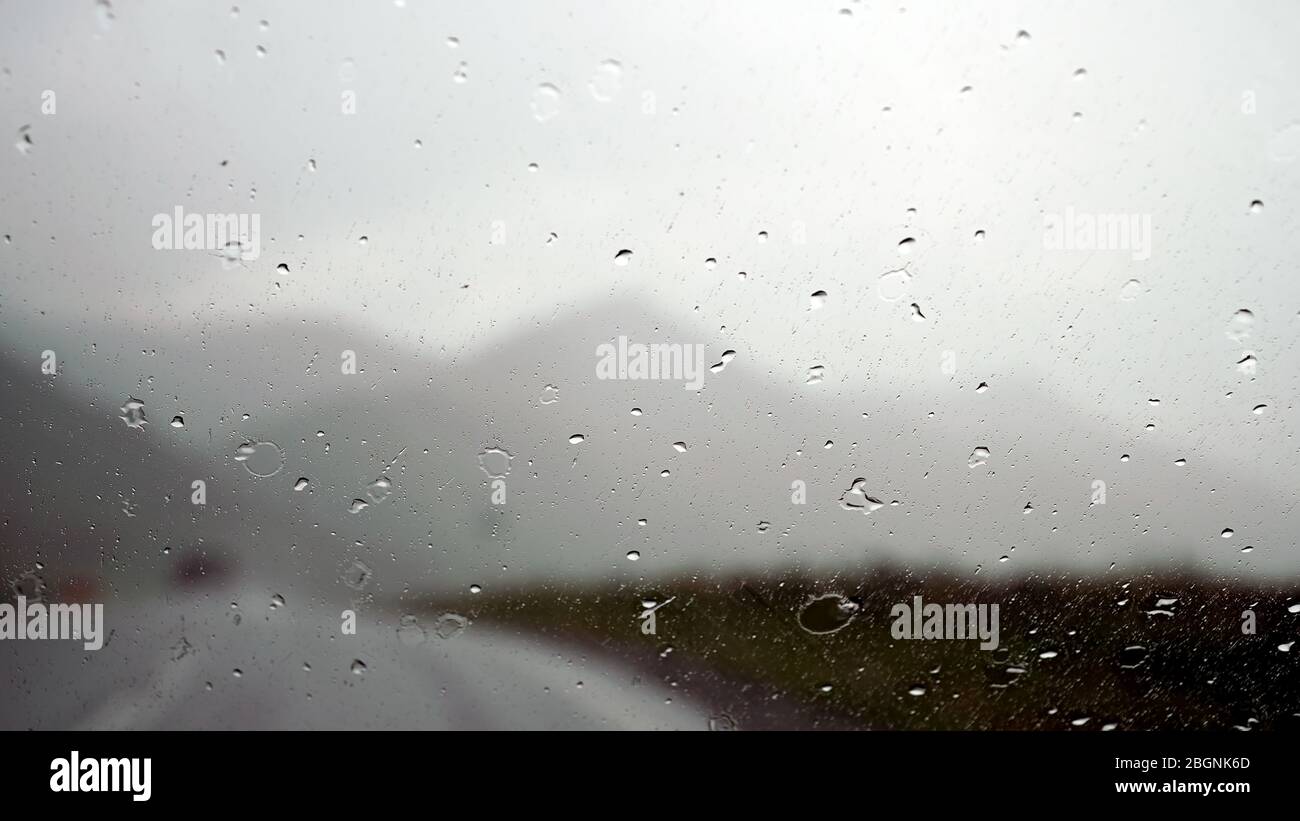 L'eau tombe sur le pare-brise un jour de pluie dans les montagnes Banque D'Images