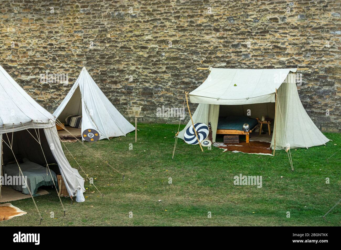 Scène médiévale sur fond historique d'un vieux mur de ville, village avec tentes de divers dessins, vue sur tentes, place de village avec ustensiles Banque D'Images