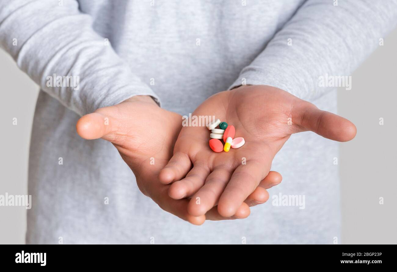 Traitement de médicament. Beaucoup de pilules lumineuses sur la main Banque D'Images