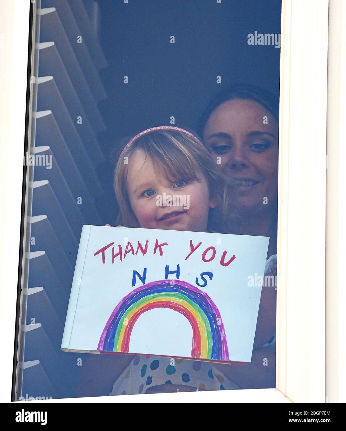 Brighton UK 22 avril 2020 - une jeune fille et sa mère bâton A Merci NHS Rainbow peinture et message à leur maison Woodingdean près de Brighton pendant le verrouillage dans la crise pandémique Coronavirus COVID-19 . Crédit: Simon Dack / Alay Live News Banque D'Images