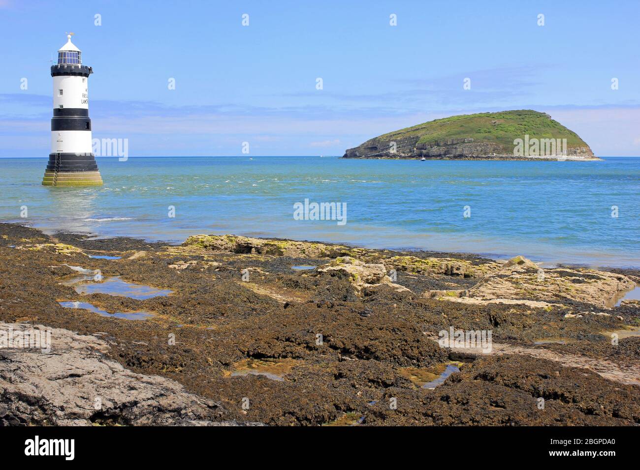 Phare de Penmon point avec l'île Puffin au loin, Anglesey, Pays de Galles, Royaume-Uni Banque D'Images
