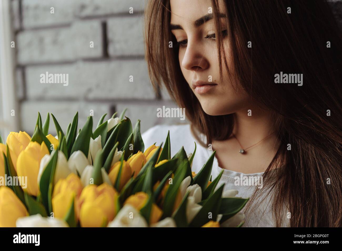 Fille regardant sur le bouquet de tulipes Banque D'Images