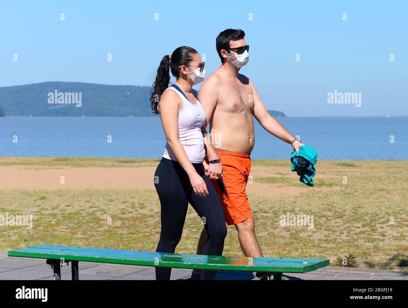 Couple marchant à l'extérieur en utilisant des masques faciaux pendant l'éclosion de Coronavirus. Pratique sportive pendant la période de quarantaine en raison de l'éclosion de covid au Brésil. Banque D'Images