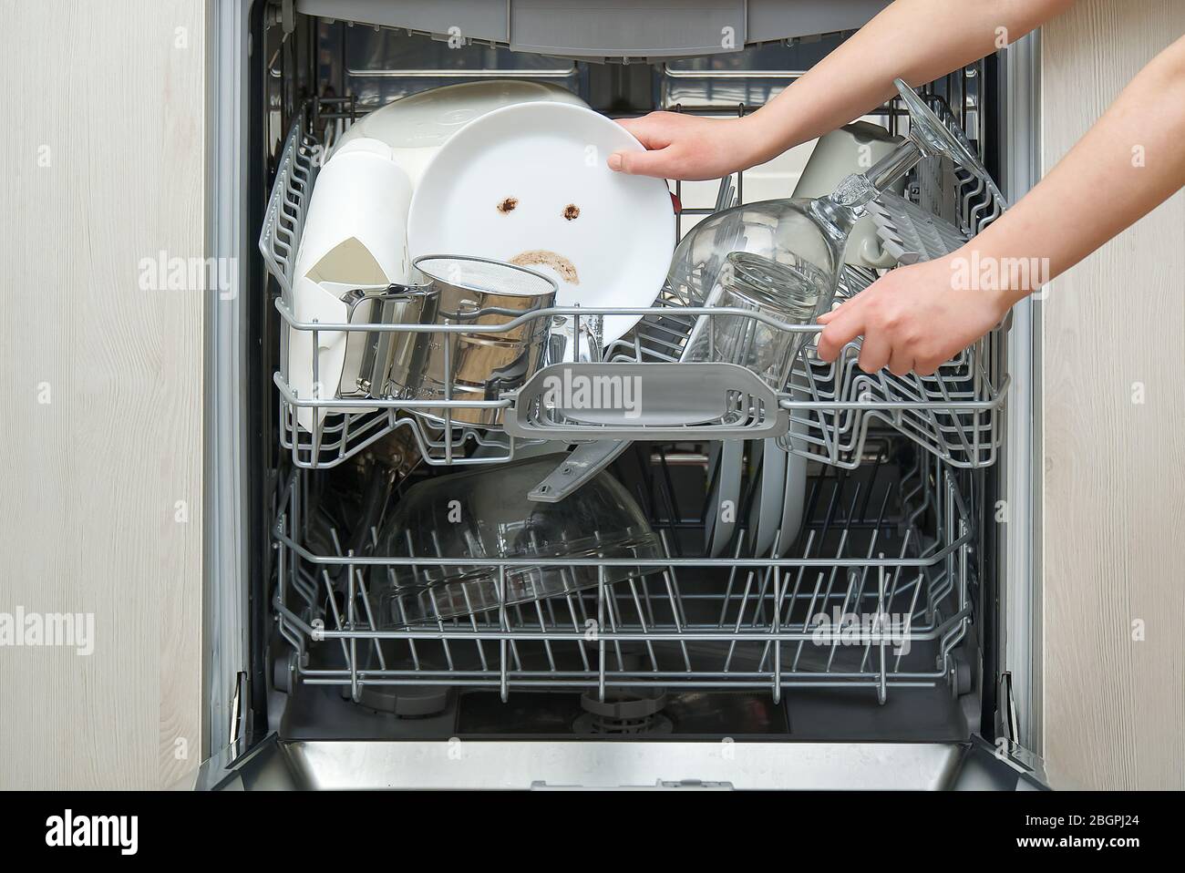 Vaisselle mal lavée au lave-vaisselle. Lave-vaisselle intégré avec plaques  blanches avant cousues et triste émotion sur plaque. Concept de machine de  lave-vaisselle cassée Photo Stock - Alamy