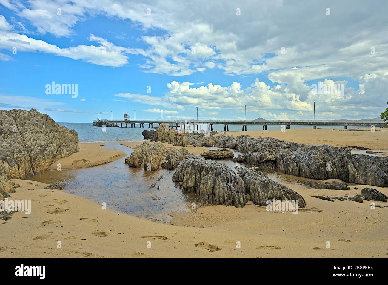 Vue sur la plage près de la jetée de Palm Cove avec des rochers Banque D'Images