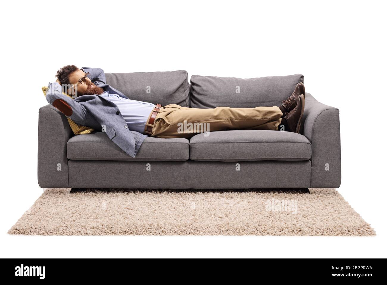 Homme barbu reposant sur un canapé après le travail isolé sur fond blanc Banque D'Images