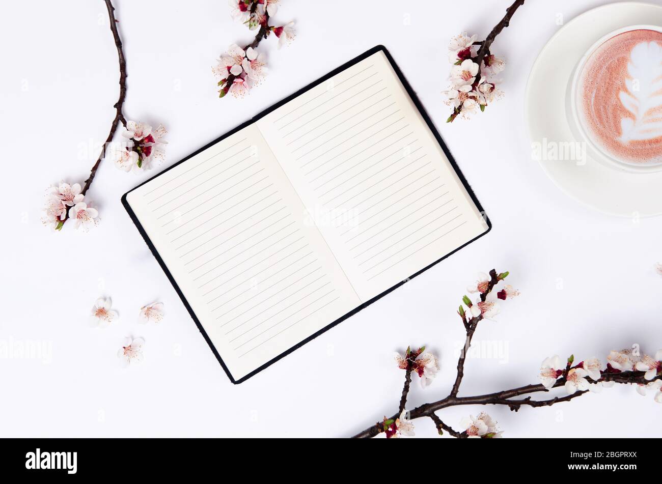 Liste de souhaits pour les plans futurs. composition de plat avec fleurs, verres et bloc-notes et café avec l'art latte Banque D'Images