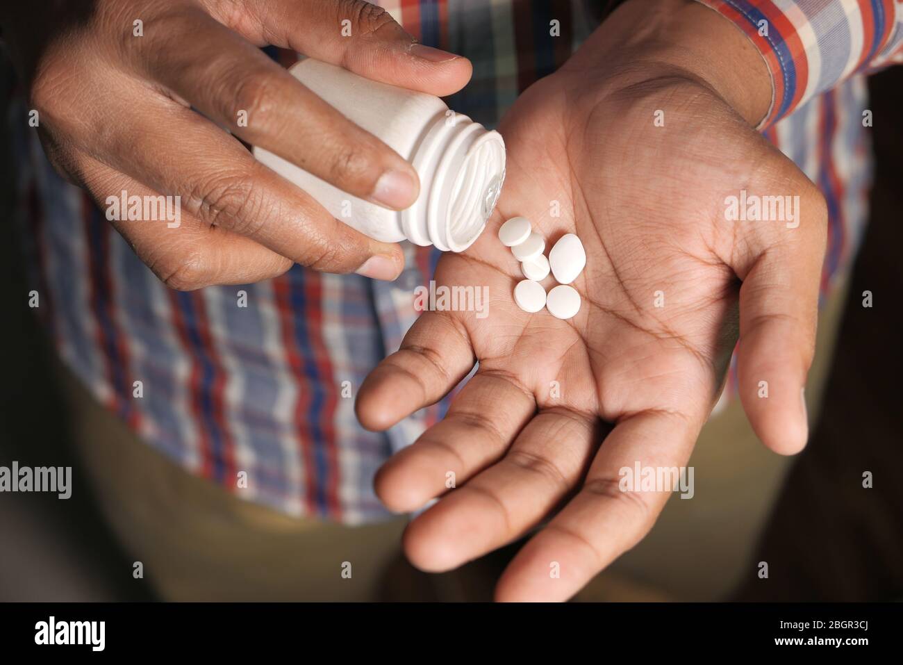 Verser les pilules de la bouteille blanche dans la paume Banque D'Images