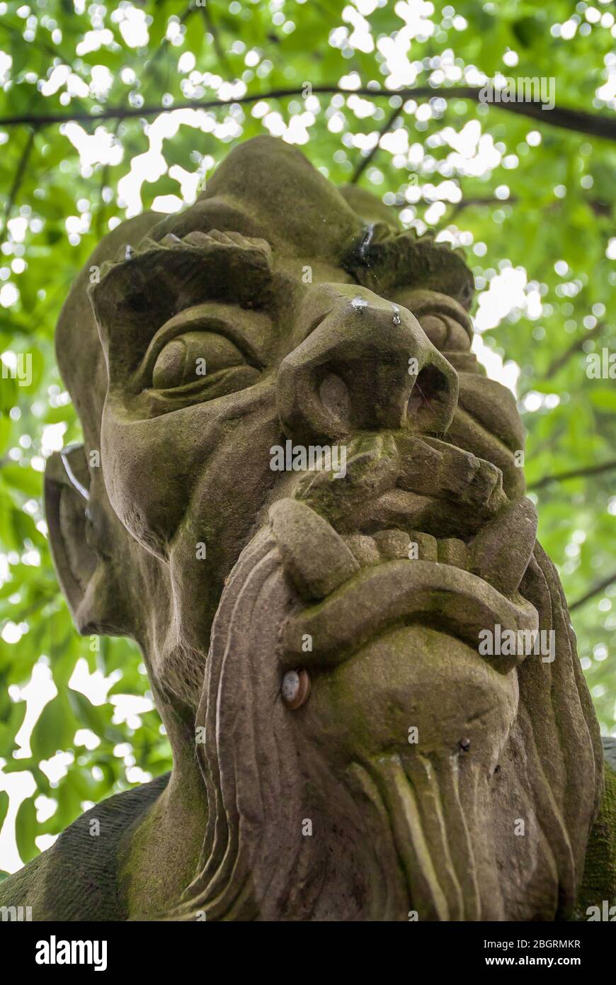 Fengdu, Chine - 8 mai 2010 : Ville fantôme, sanctuaire historique. Vue frontale de la face masculine agressive en colère avec une grosse barbe de teethand sur une statue grise avec Banque D'Images