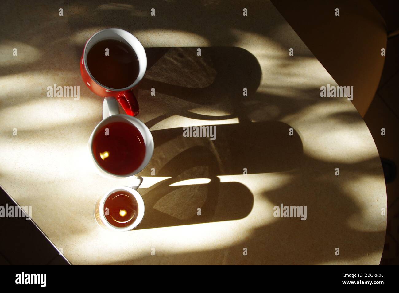 Trois tasses de thé sur la table. Prenez un verre au petit-déjeuner du matin. Un concept métaphore de maison, d'amitié, de chaleur familiale et de proximité. Banque D'Images