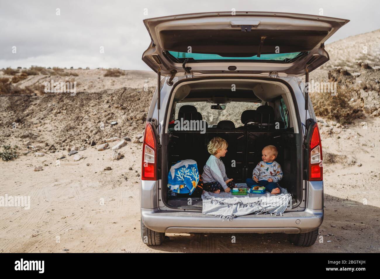les enfants qui pique-niquent dans le coffre de leur voiture pendant les vacances Banque D'Images