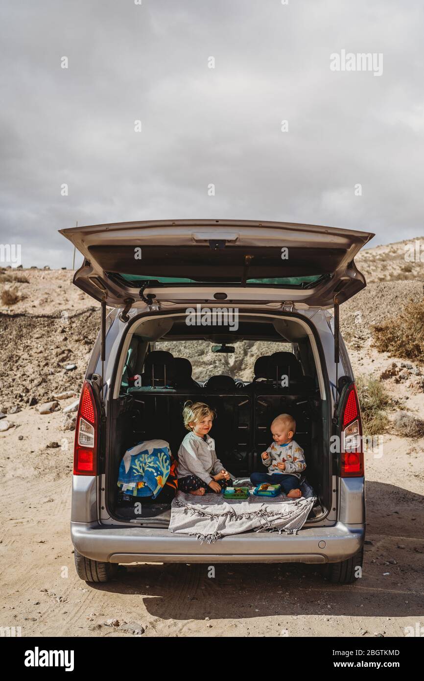 les enfants qui pique-niquent dans le coffre de leur voiture pendant les vacances Banque D'Images
