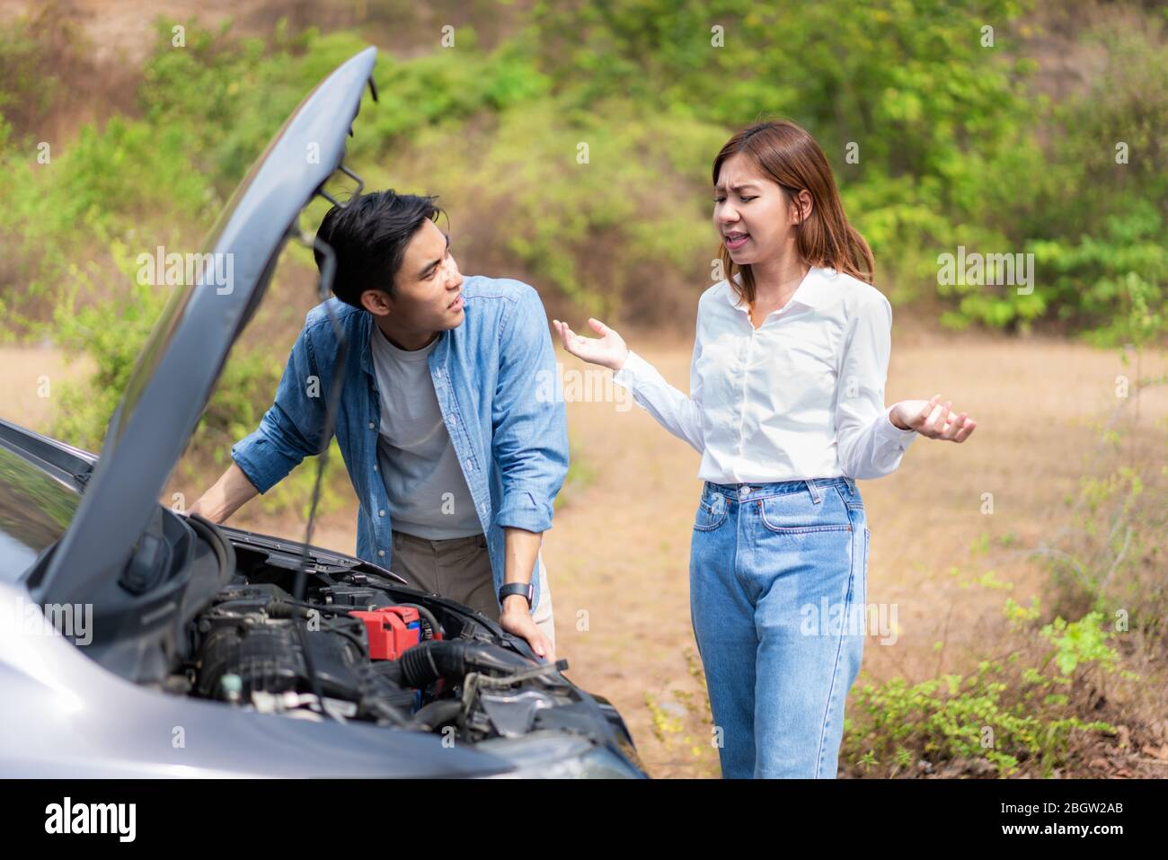 Un jeune couple asiatique avec un homme et une femme sur la route ayant un problème de panne de moteur de voiture sur la route et une femme regardant le stress quand un homme ne peut pas se représenter Banque D'Images