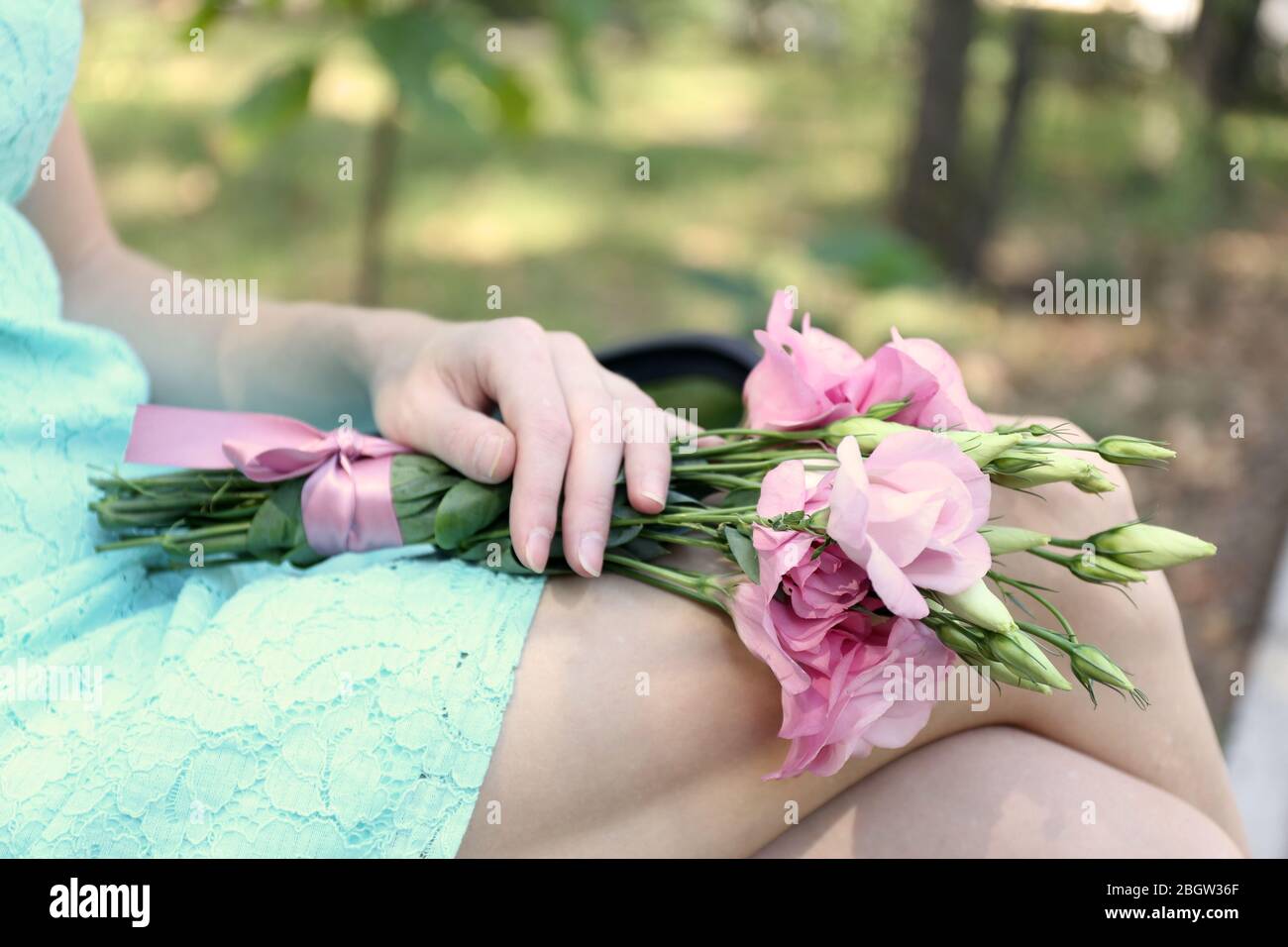 Femme tenant un beau bouquet de fleurs d'eustoma, à l'extérieur Banque D'Images