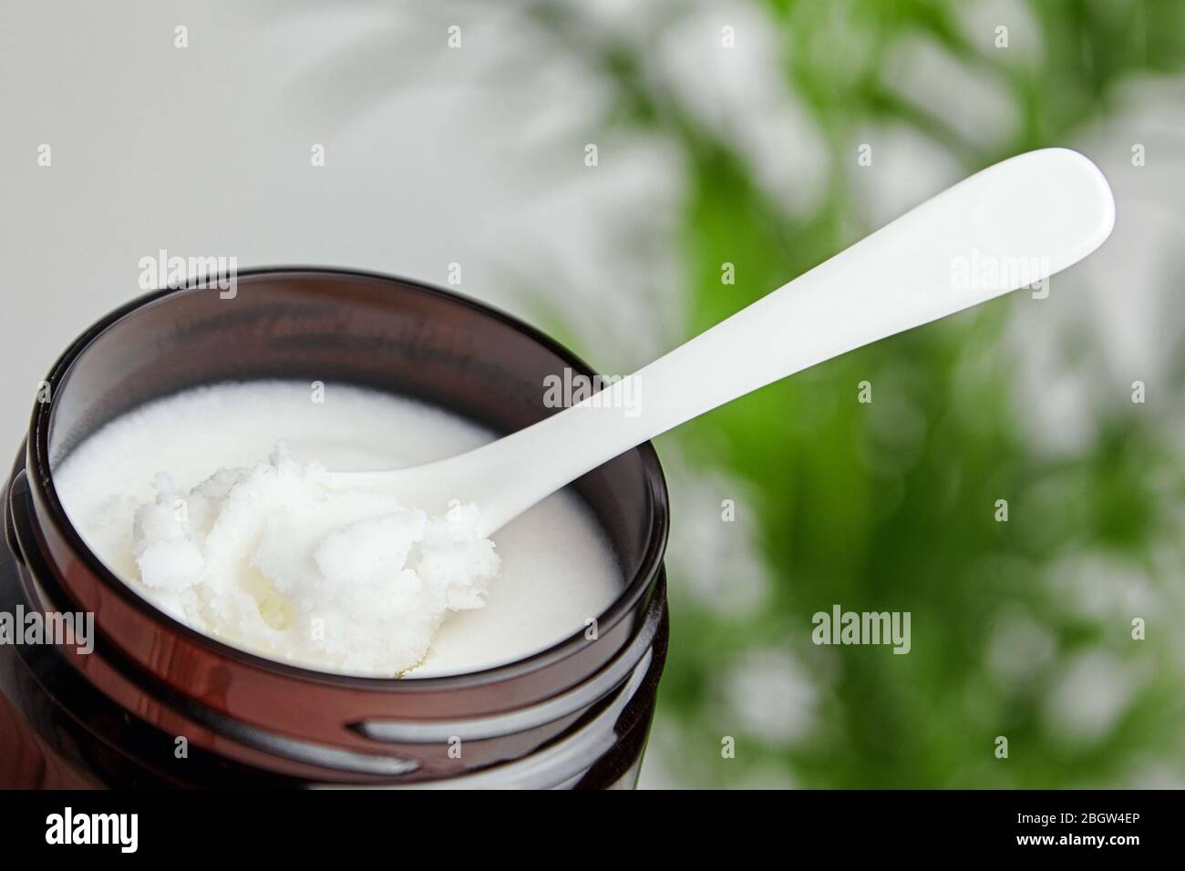 Beurre de karité dans un pot avec cuillère, produit cosmétique pour hydrater la peau. Banque D'Images