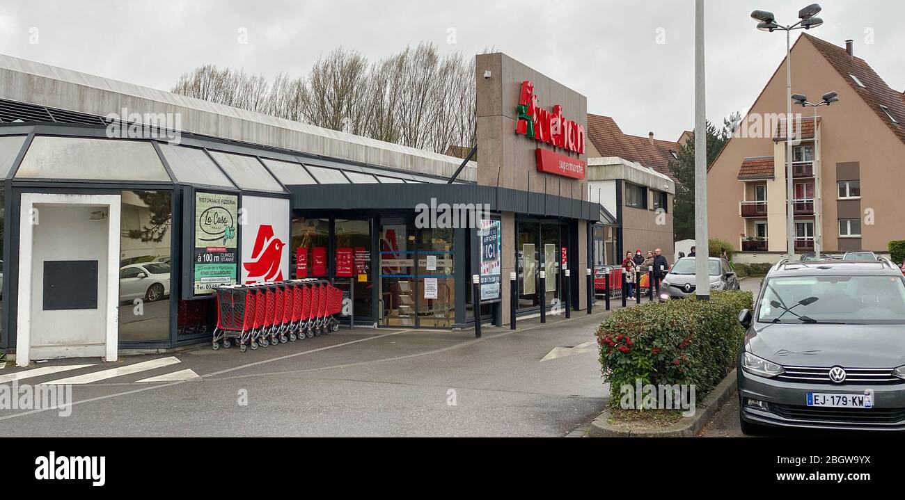 Paris, France - 21 mars 2020: Supermarché français Auchan à Robertsau avec files d'attente de personnes à distance pendant Coronavirus Covid-19 pandémie de verrouillage Banque D'Images