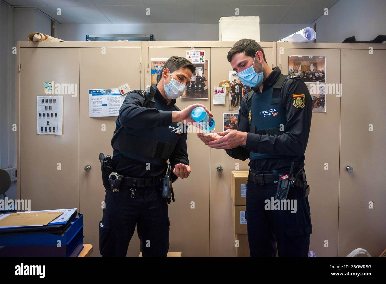 Les membres de la police nationale espagnole sont vus désinfecter leurs  mains dans un bureau au milieu de la maladie de l'éclosion de coronavirus  COVID-19. La police nationale espagnole de Malaga, sous