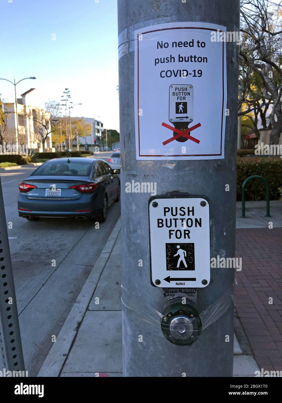 Bouton de passage pour piétons mis à jour avec le panneau Covid 19 indiquant qu'il n'est pas nécessaire d'appuyer sur le bouton dans Culver City, CA Banque D'Images