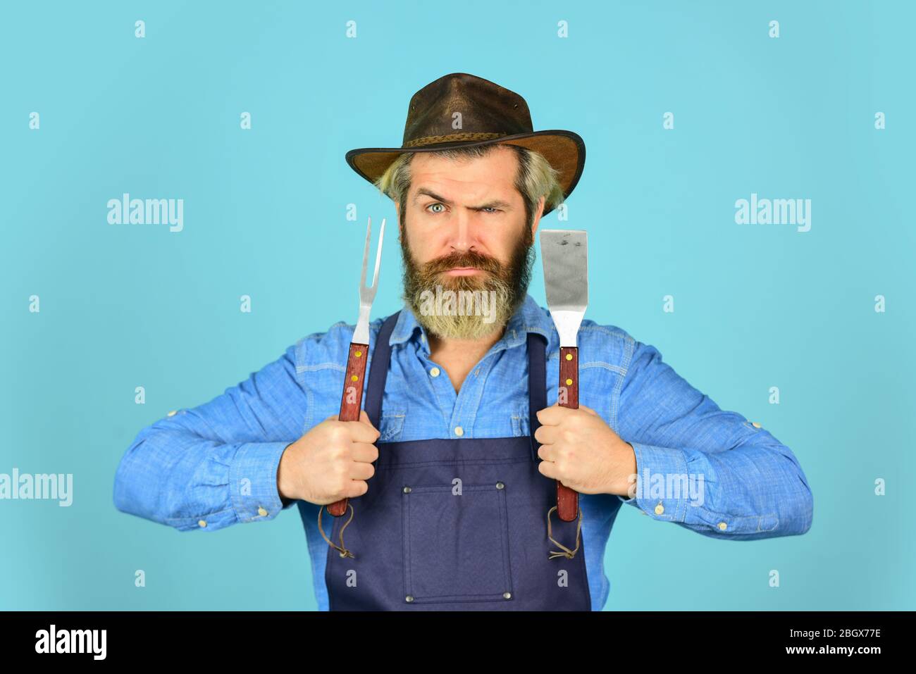 camping. Le défi de la cuisine ultime. Préparez le dîner pour la famille. Utilisez des ustensiles de cuisine et divers produits. Le chef mûr utilise des ustensiles de cuisine pour le barbecue. Outils pour la torréfaction de viande. Qui cuisinent mieux. Banque D'Images