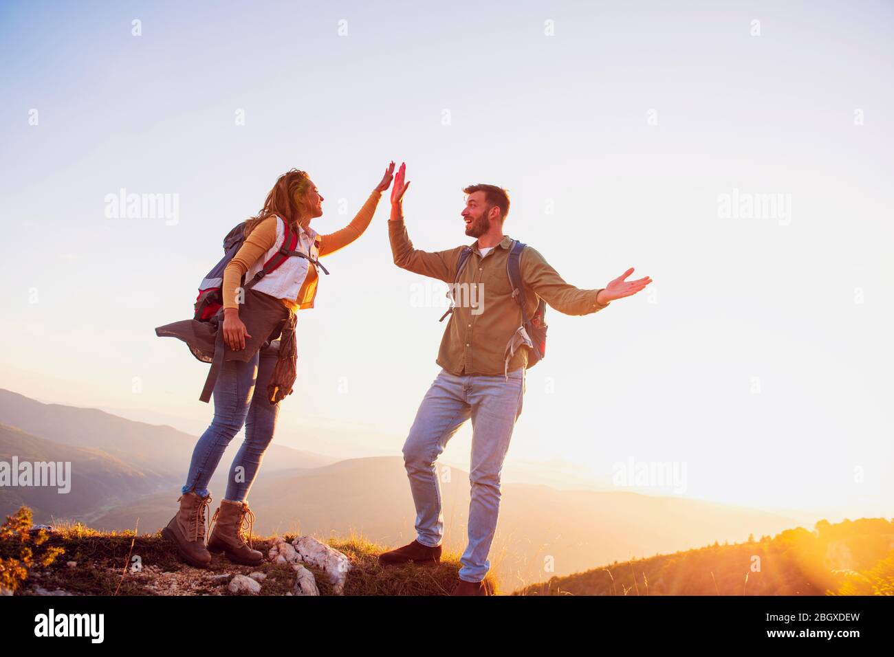 Couple sur un sommet d'une montagne secouant les mains levées Banque D'Images