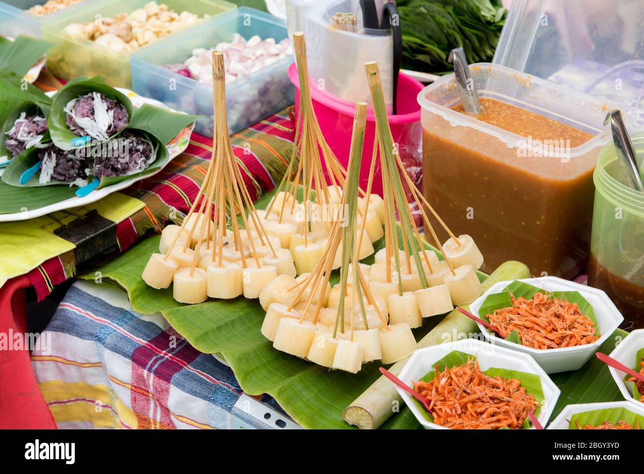 Morceaux de canne à sucre brute sur des bâtons à vendre dans la rue de marche en Thaïlande. Banque D'Images